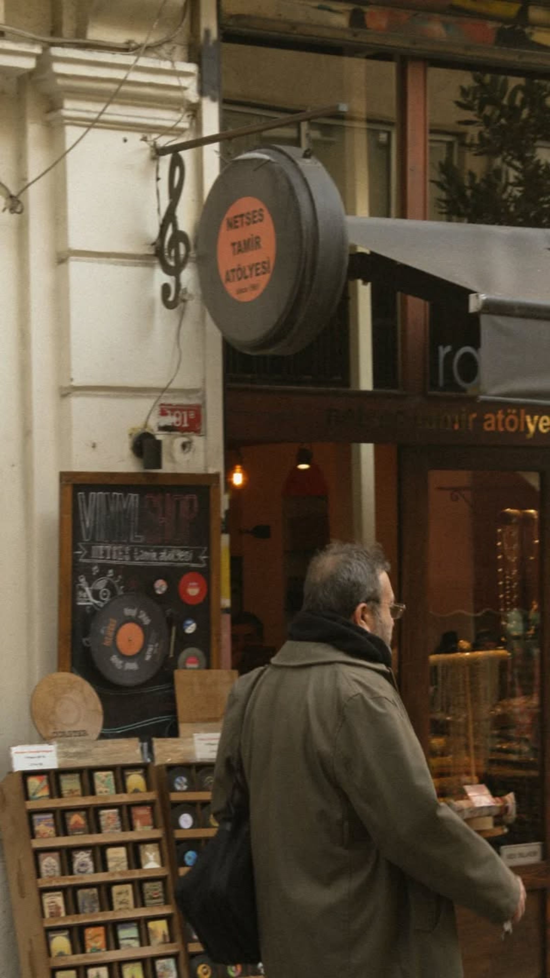 Street view in Istanbul featuring a music store and passerby captured in a candid moment.