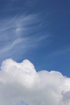 Tranquil blue sky with soft, fluffy clouds, perfect for springtime ambiance.