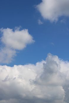A serene view of fluffy white clouds against a bright blue sky over Milano.