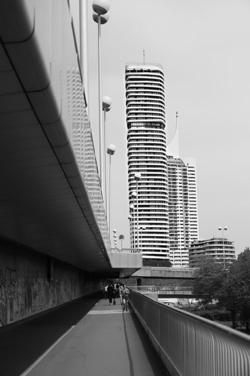 Free Black and white photo of modern skyscrapers in Vienna with a sleek bridge in the foreground. Stock Photo