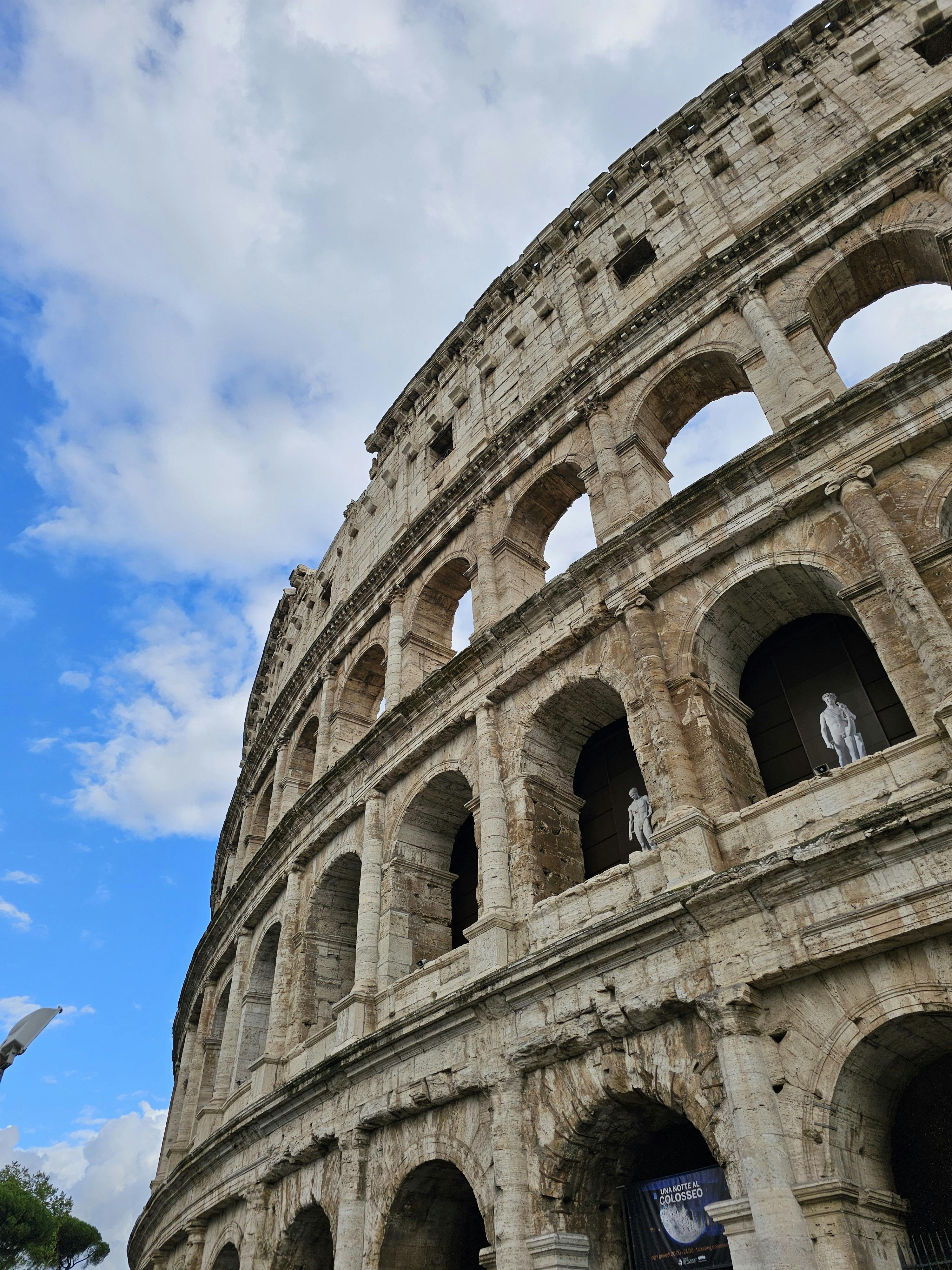 Free Stunning upward angle of the Colosseum against a bright blue sky in Rome, Italy. Stock Photo
