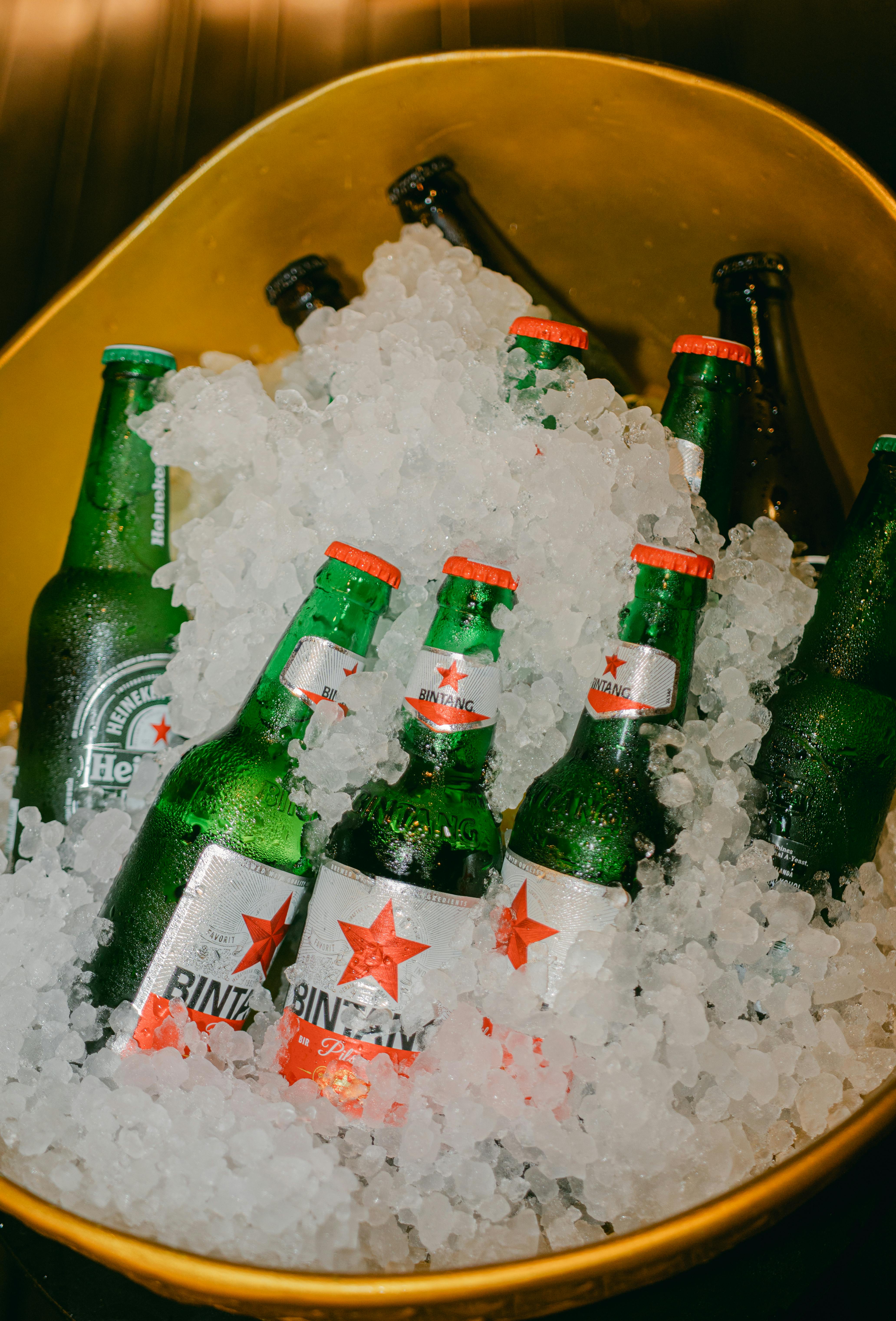 免費 黃色桶中裝有冰塊的冷啤酒瓶，準備參加派對。 圖庫相片