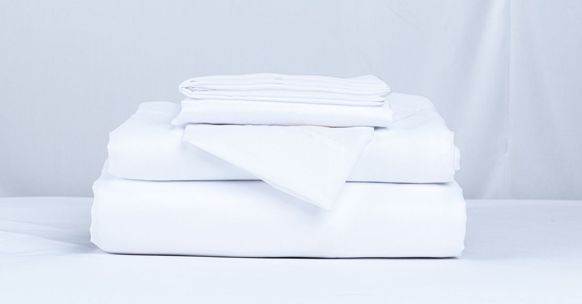 Roupa de cama dobrada Pilha de roupa de cama branca bem dobrada