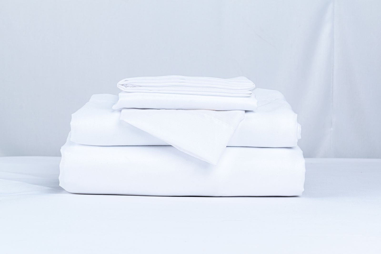A neat stack of crisp white bed linens