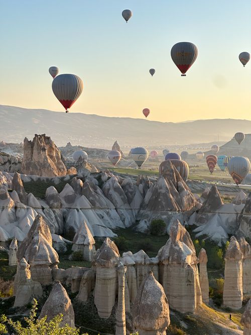 Free Hot air balloons soar over Cappadocia's unique rock formations at sunrise. Stock Photo