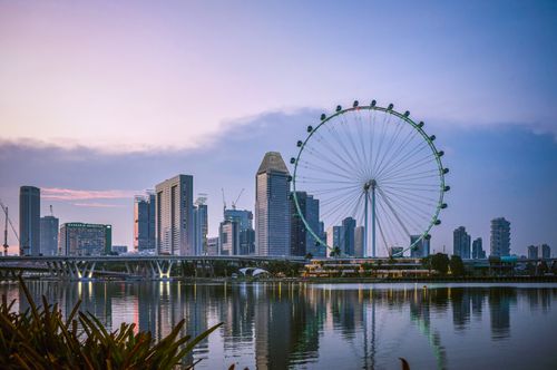 Free Captivating view of Singapore skyline with iconic Ferris wheel during sunset over Marina Bay. Stock Photo