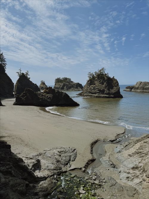 Free Stunning rocky cliffs and sandy beach under a bright blue sky at the coast. Stock Photo