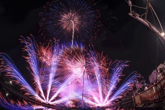 Stunning fireworks explode in vibrant colors over a city at night.