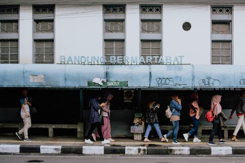 Free A lively street scene at a bus station in Bandung, Indonesia with people walking by. Stock Photo