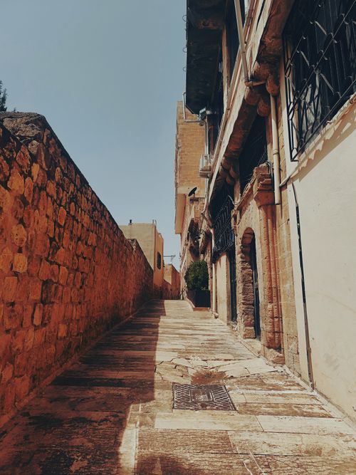 Free Explore a charming ancient cobblestone alley in Mardin, Türkiye, capturing timeless architecture. Stock Photo