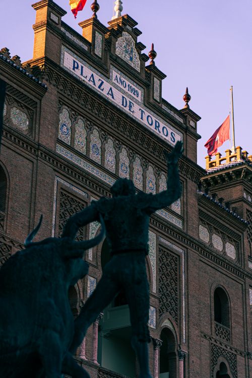 Free Sculpture of a bullfighter and bull in front of Plaza de Toros de Las Ventas, Madrid. Stock Photo