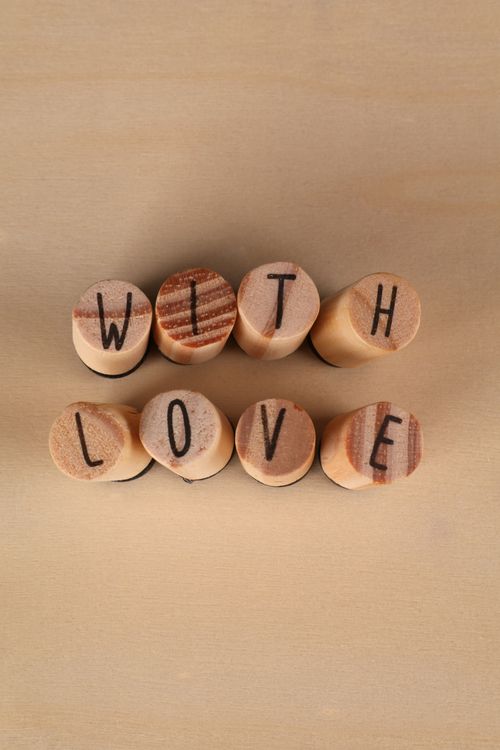 Free Wooden stamp blocks arranged to spell 'With Love', creating a warm and personal touch. Stock Photo