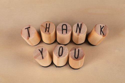 Free Wooden letter stamps spelling out 'Thank You' on a light background. Stock Photo