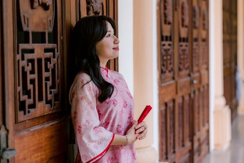 Free Beautiful woman in traditional dress standing by wooden doors indoors. Stock Photo