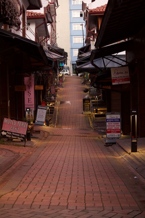 Free Quiet bazaar street with colorful shops and cobblestone path at sunset. Stock Photo