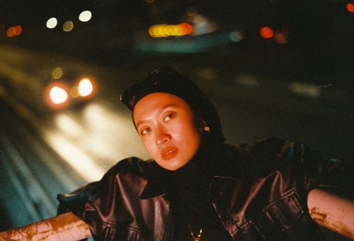 Free Cinematic urban night portrait with captivating bokeh lights and an enigmatic expression. Stock Photo