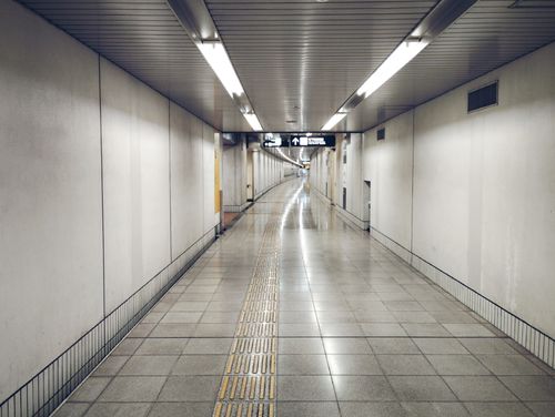 Free A deserted subway station corridor with geometric ceiling and tactile paving, captured in high resolution. Stock Photo