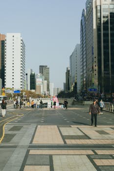 Street view of Seoul city with skyscrapers and people, showcasing urban life and architecture.
