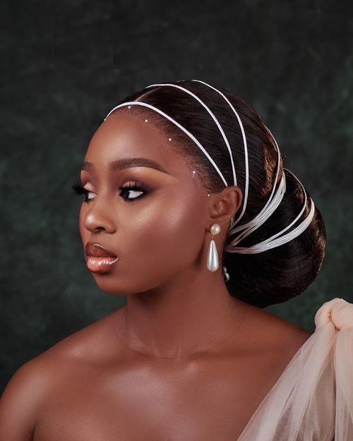 Free Stunning portrait of a woman with pearl earrings and headpiece, set against a dark green backdrop. Stock Photo