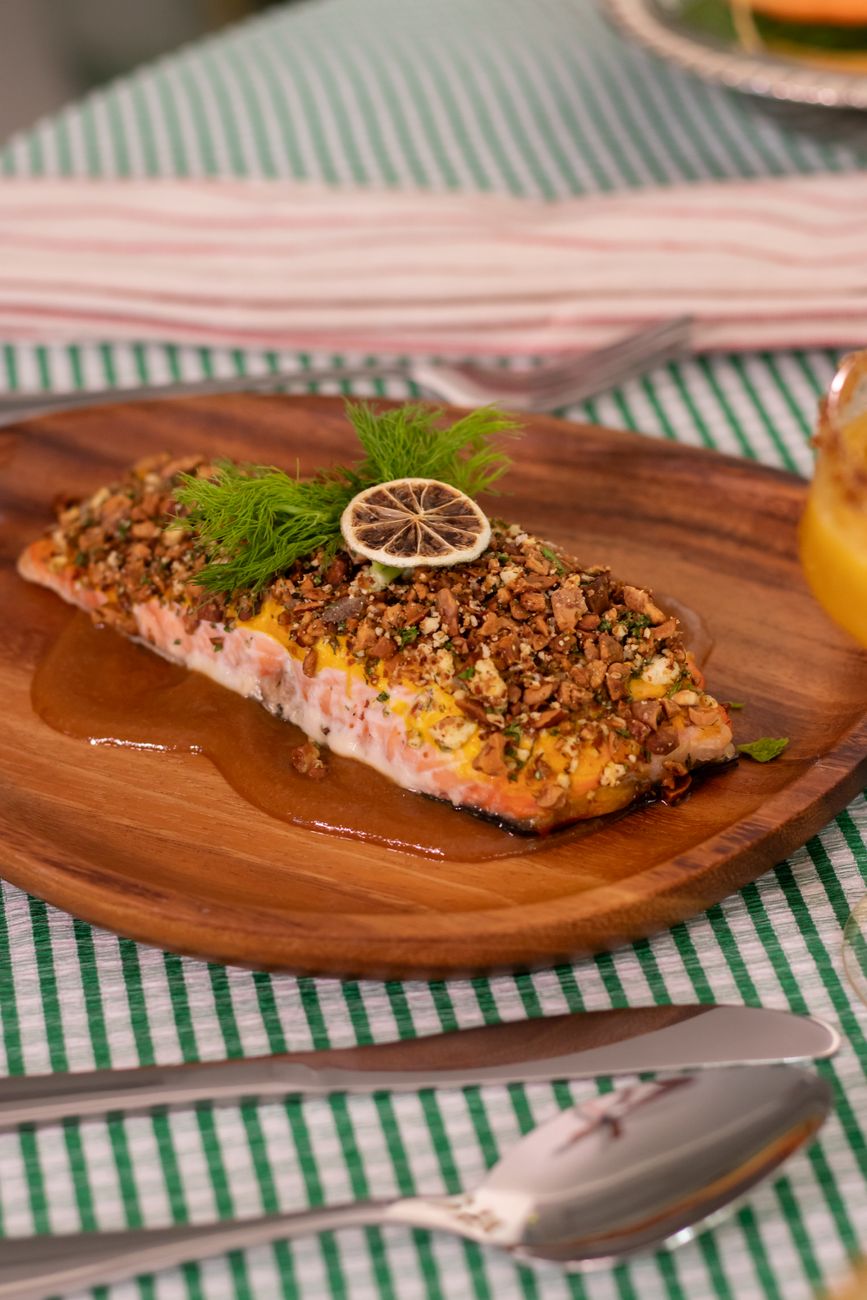 Thick salmon fillet with dark red berbere spice crust, glistening with golden Ethiopian spiced butter on a white plate
