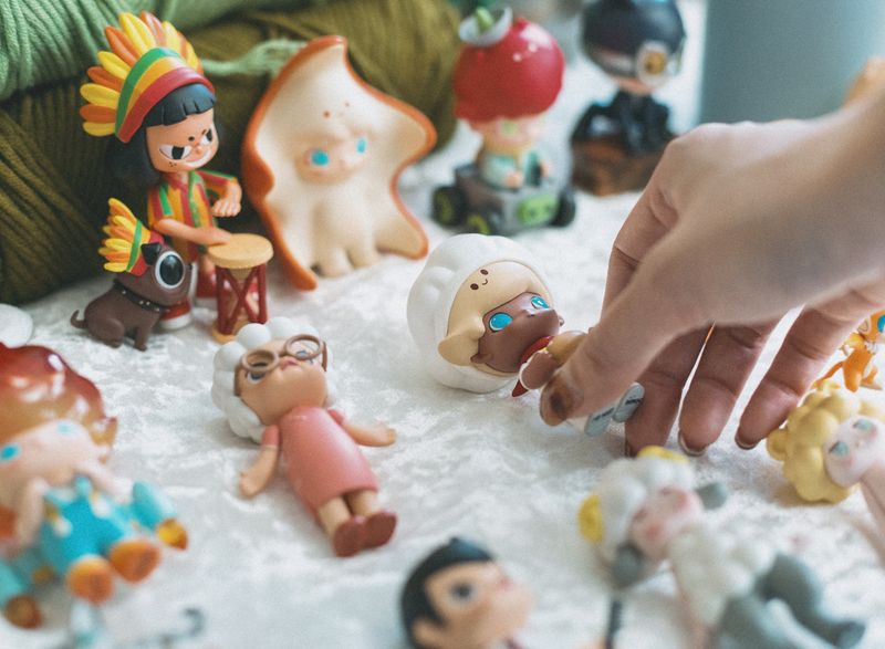 Colorful collection of artistic figurines displayed representing blind box collectibles including BaiChaoHui mystery boxes