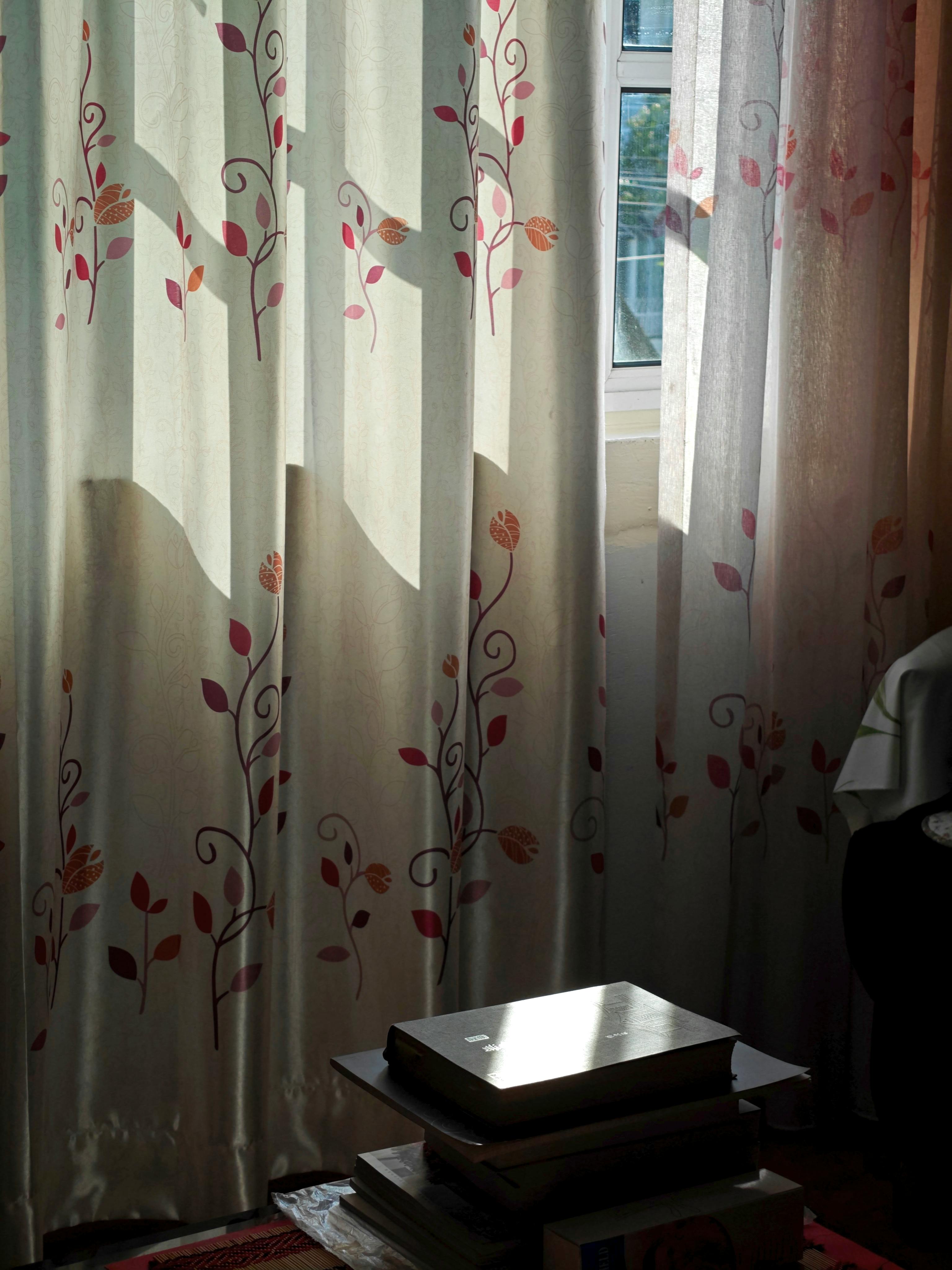 Gratuit Lumina soarelui se revarsă prin perdelele florale, creând o atmosferă confortabilă. Fotografie de stoc