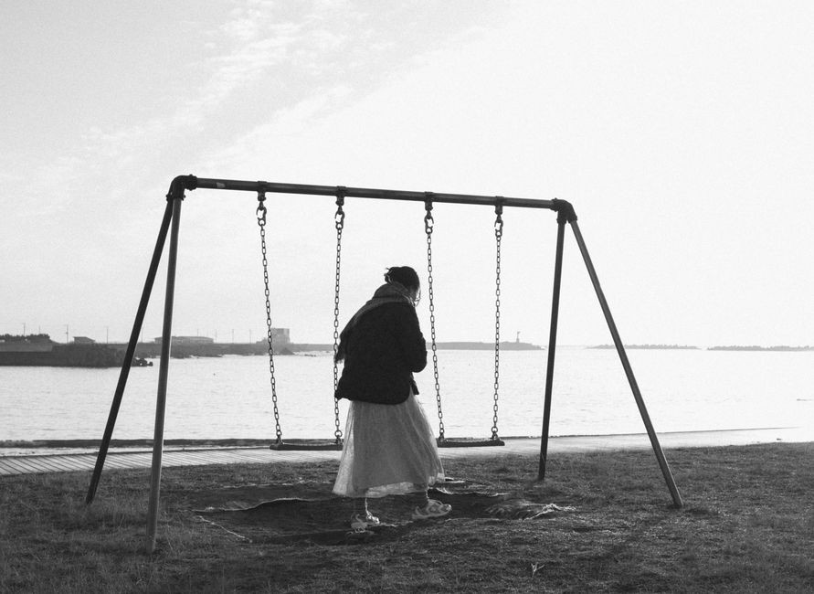 千葉県の海辺でブランコに乗った人の穏やかな白黒写真。