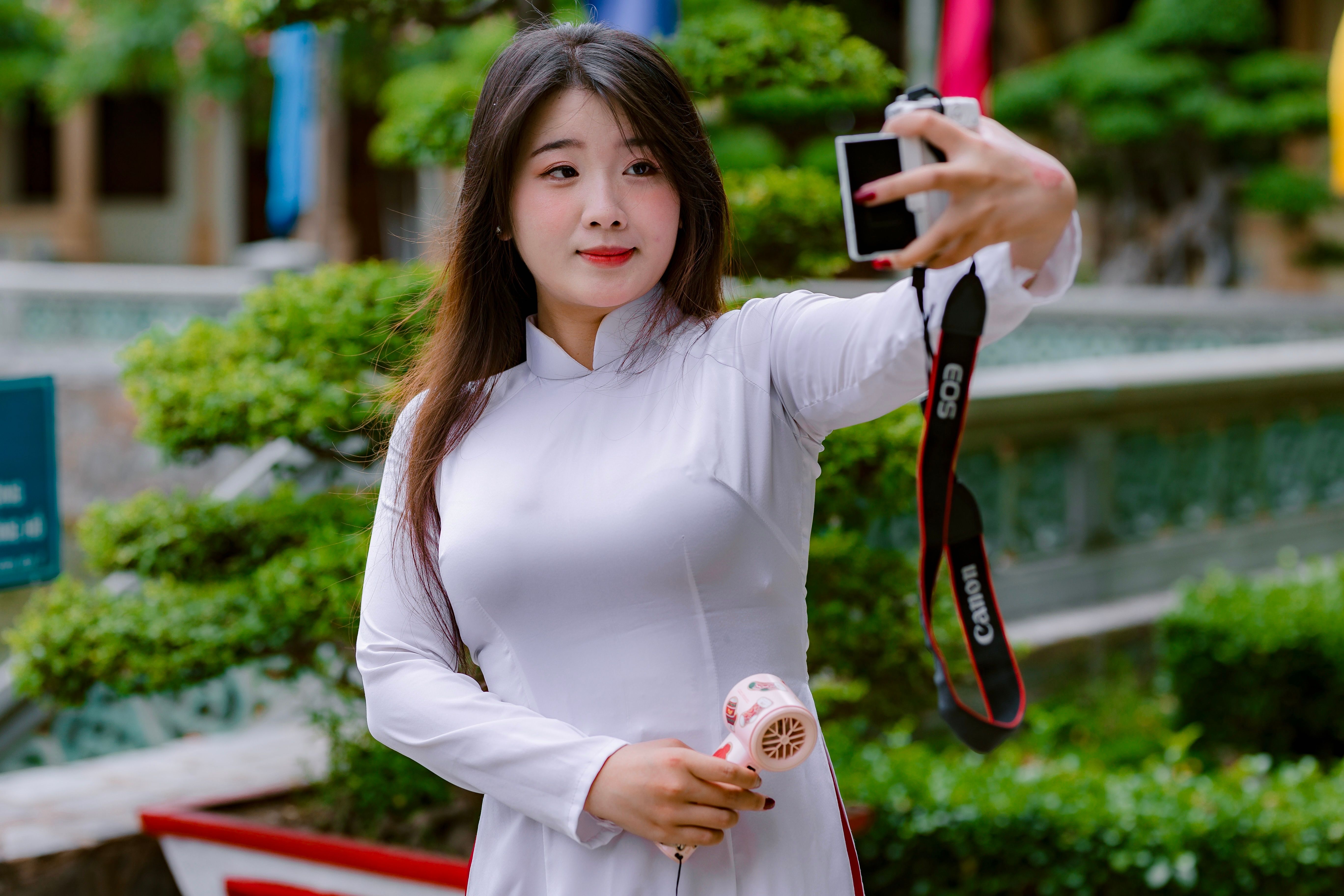Woman in White Dress Taking a Selfie Outdoors