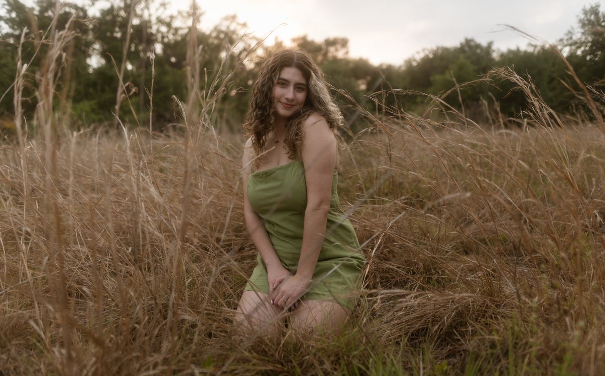 Woman in Green Dress Sitting in Tall Grass Field · Free Stock Photo