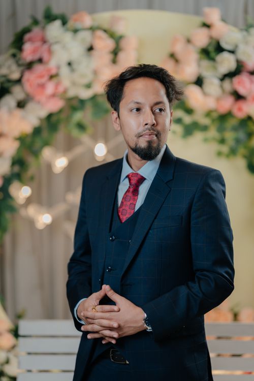 Free Portrait of a man in formal suit with floral background, ideal for professional themes. Stock Photo