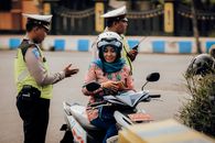 A motorcyclist converses with police officers in Bangkalan, East Java, Indonesia.