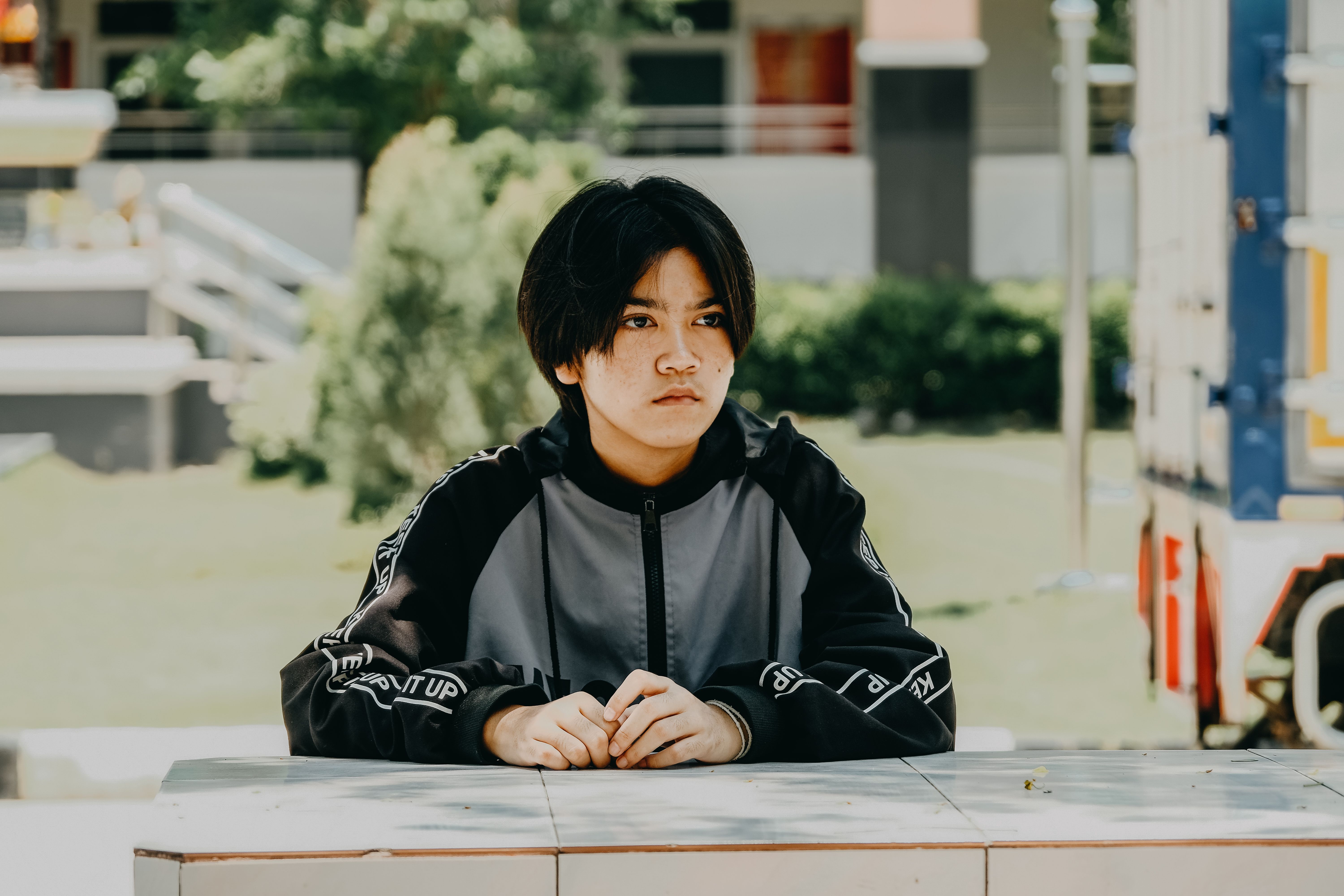 Teenager Sitting Outdoors at a Table