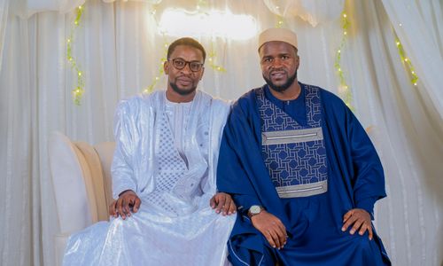 Free Two men wearing traditional African clothing pose elegantly inside a decorated room. Stock Photo