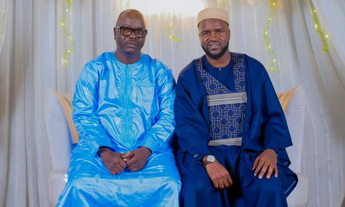 Free Two men dressed in vibrant traditional attire sitting elegantly in an indoor setting. Stock Photo