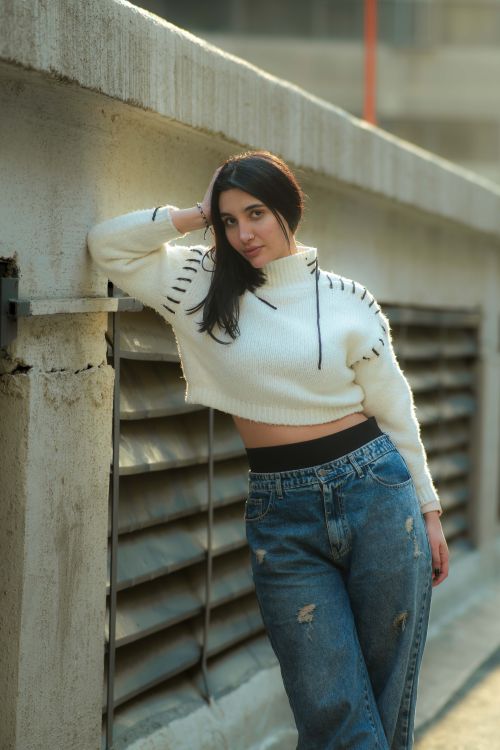 Free A fashionable young woman poses confidently in a city environment, showcasing modern style. Stock Photo