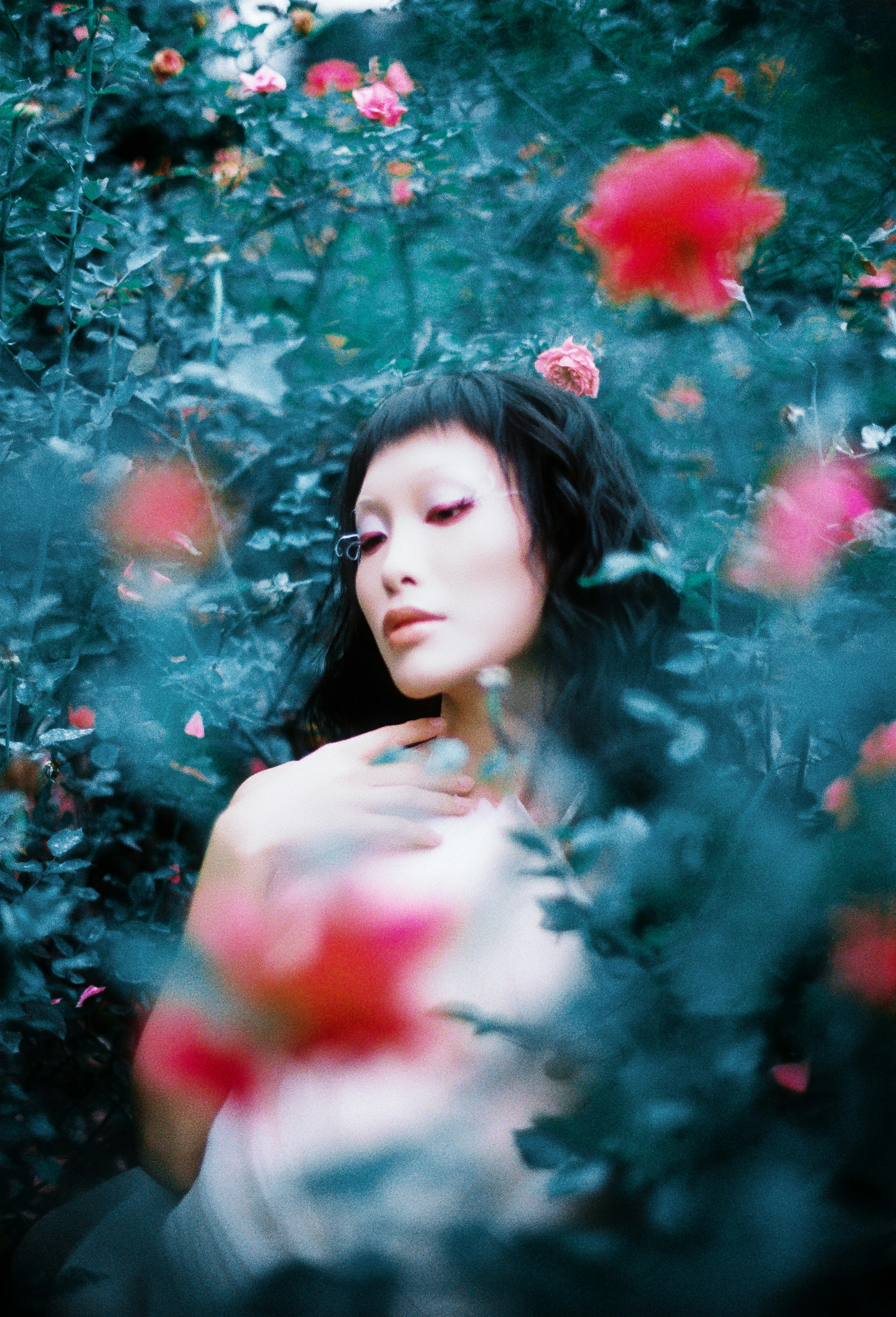 Surreal portrait of a woman surrounded by vibrant blooms in a mystical garden setting.
