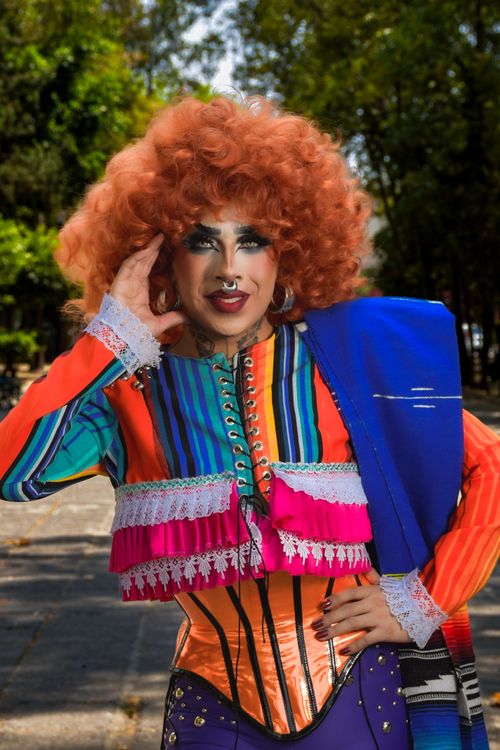 Free A lively drag performer in colorful attire poses confidently outdoors, showcasing vibrant fashion and makeup. Stock Photo