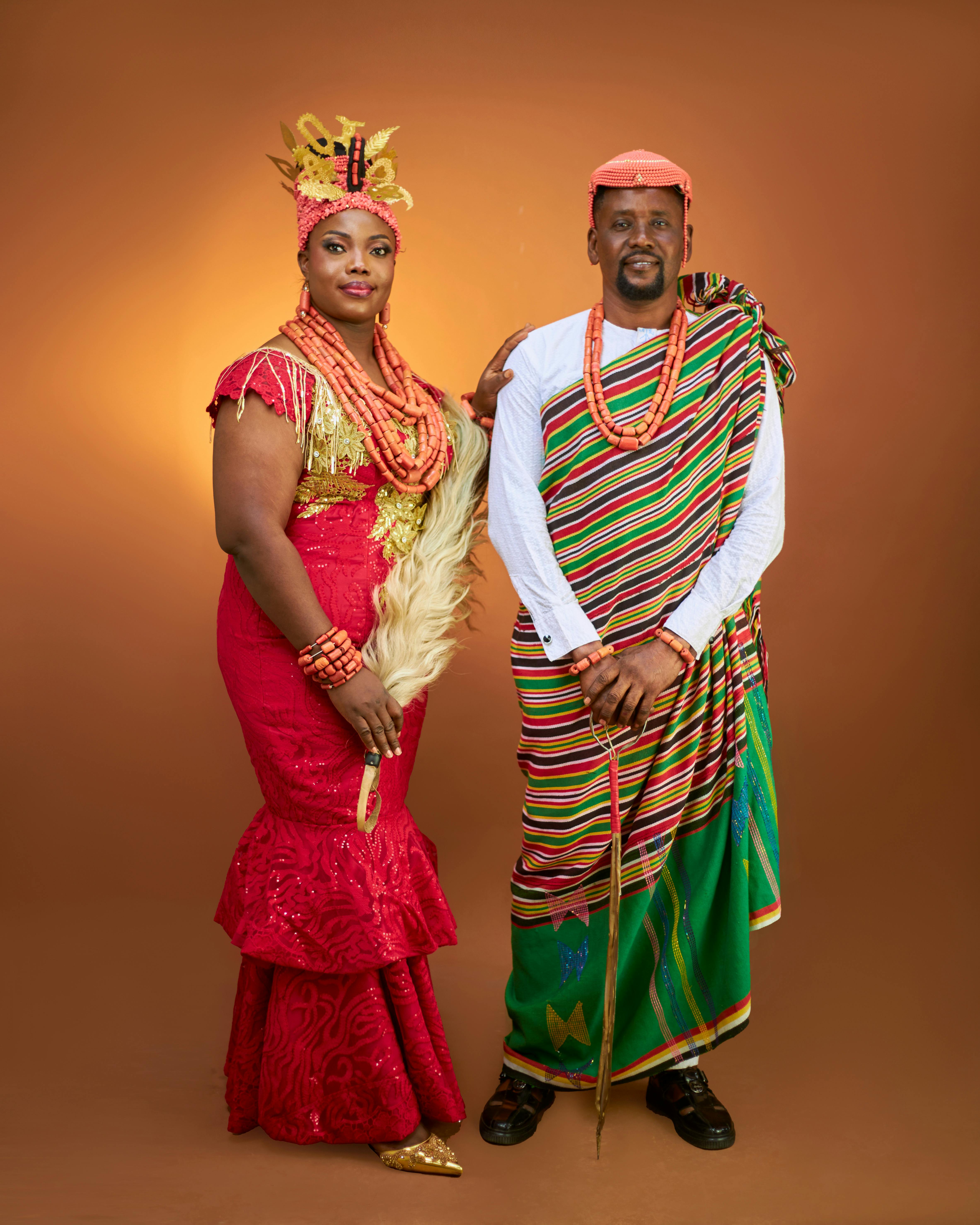 Elegant couple in vibrant African traditional attire with rich colors and cultural accessories.