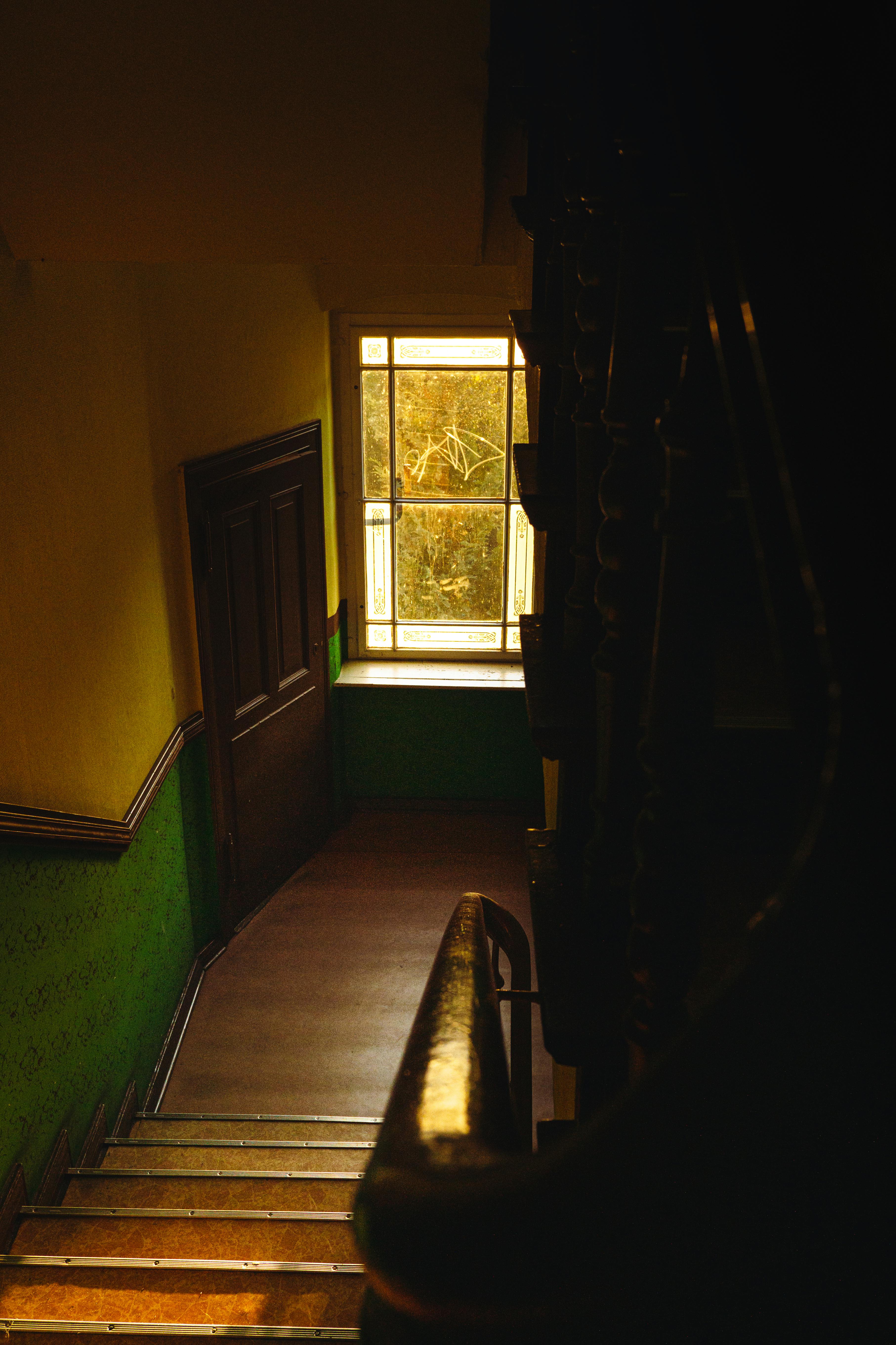 Gratis Escalera poco iluminada en un edificio histórico con tonos cálidos y ambiente vintage. Foto de stock