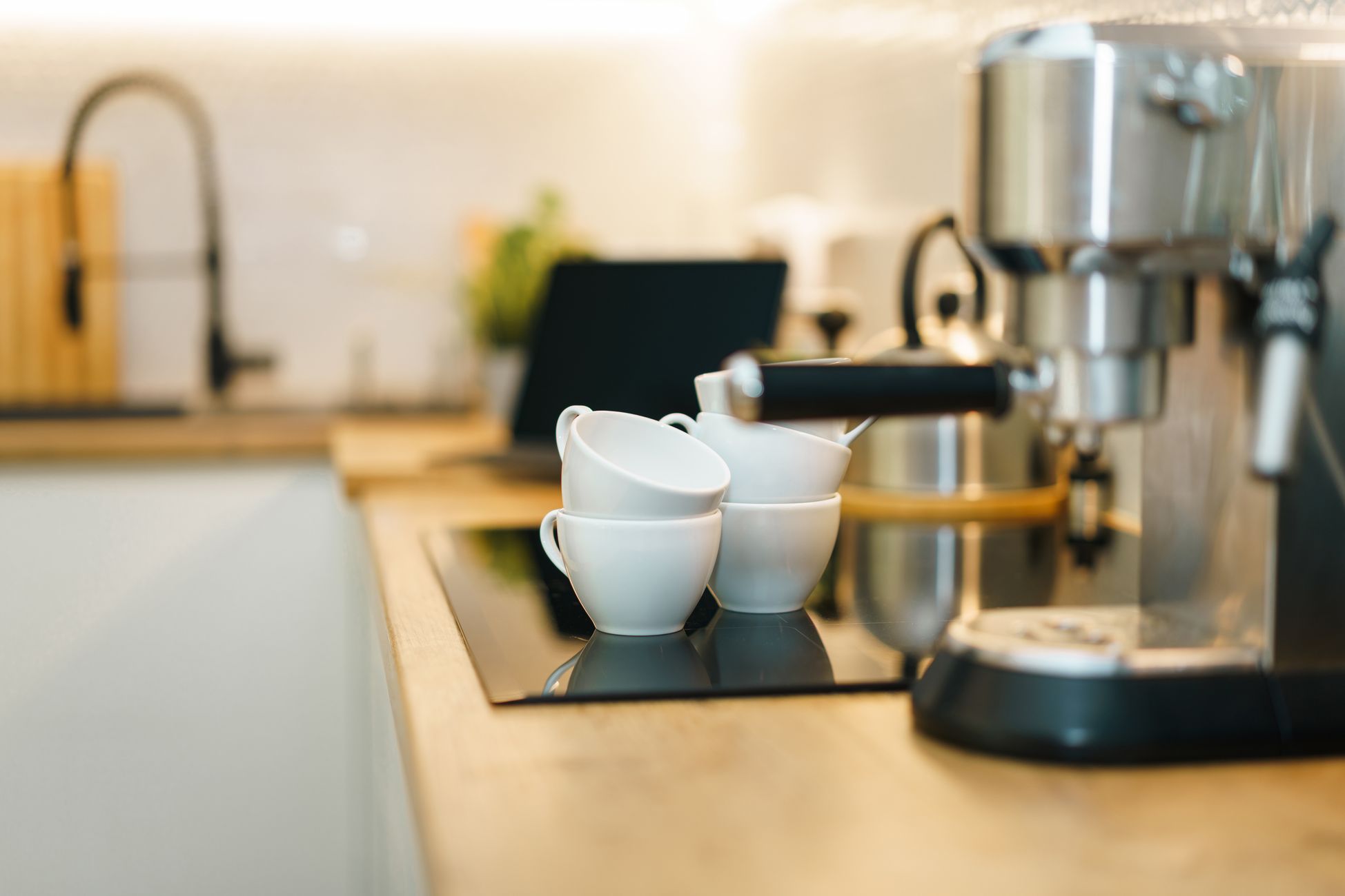 A modern espresso machine with coffee cups on a kitchen counter, showcasing a cozy and inviting setup.