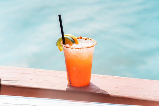 Spicy margarita with lime and orange by the ocean, perfect summer refreshment.