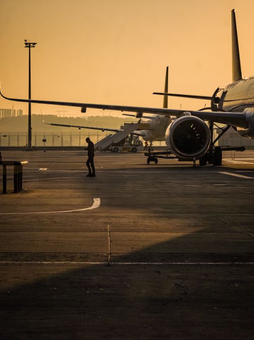 Free Airplanes parked at Istanbul airport during sunset, capturing a vibrant and moody ambiance. Stock Photo