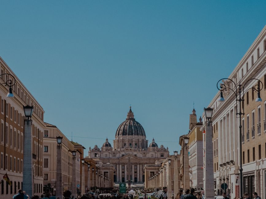 A vibrant view of St. Peter's Basilica in Vatican City with bustling street life.