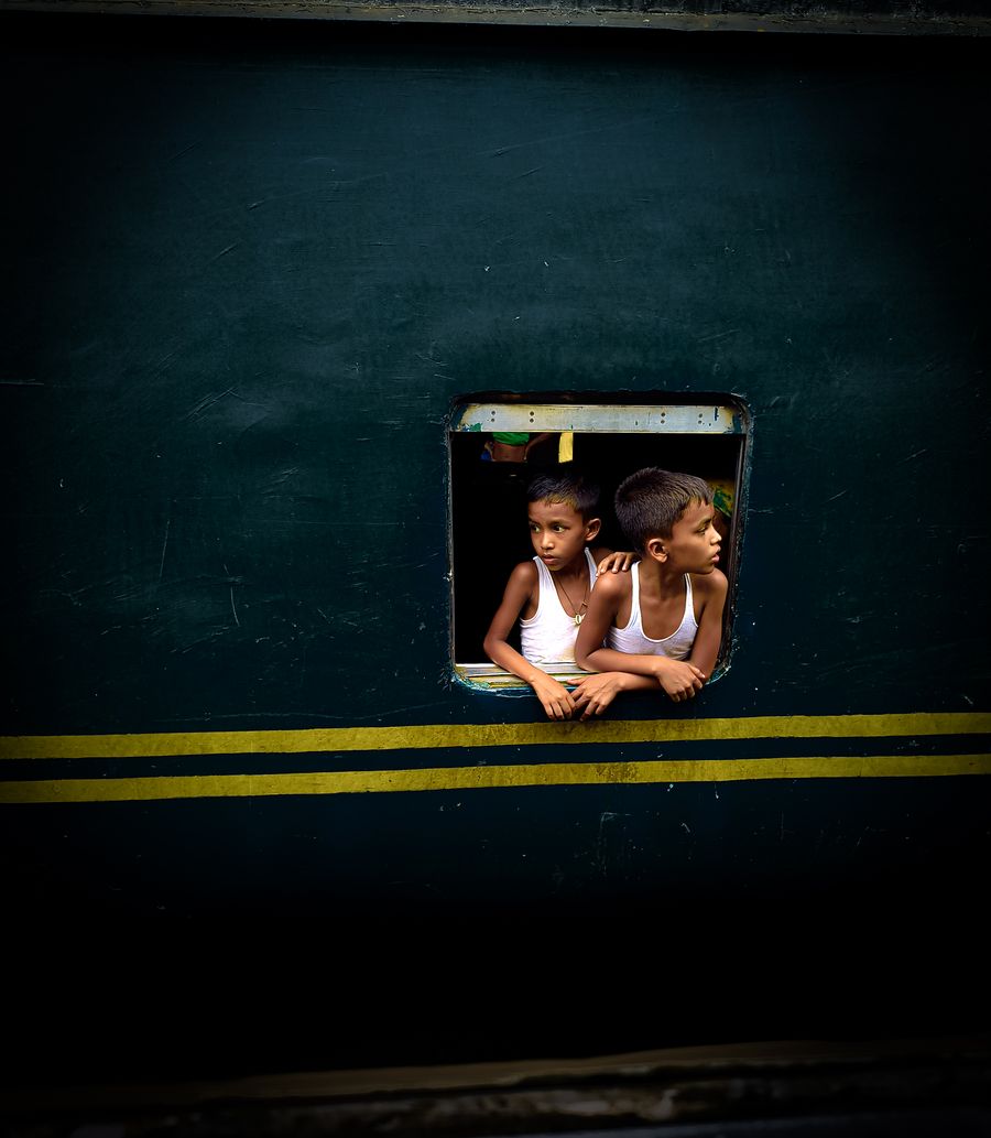 Boys gazing out a train window in Dhaka