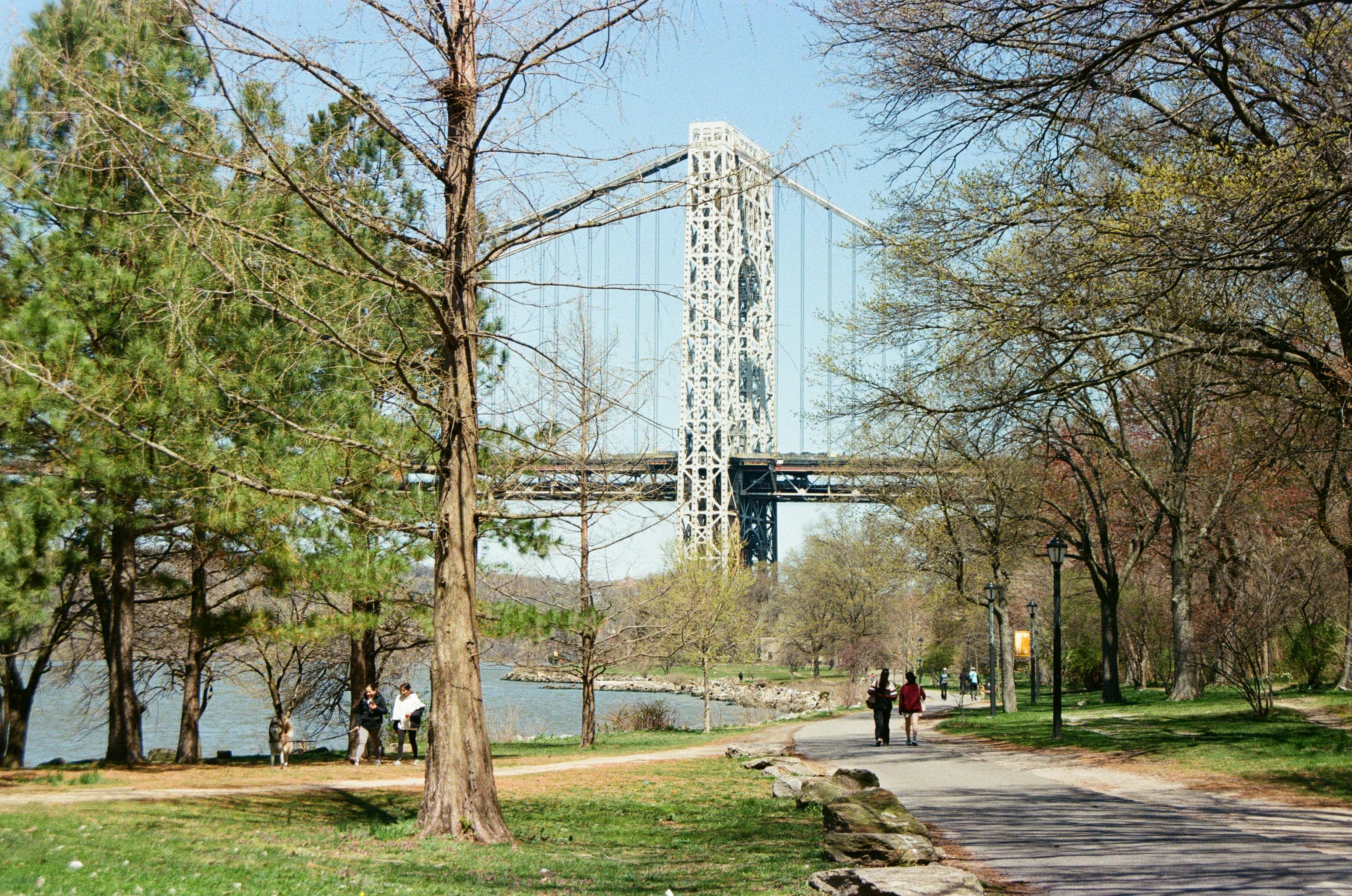 A serene view of the George Washington Bridge from Riverside Park on a sunny spring day.