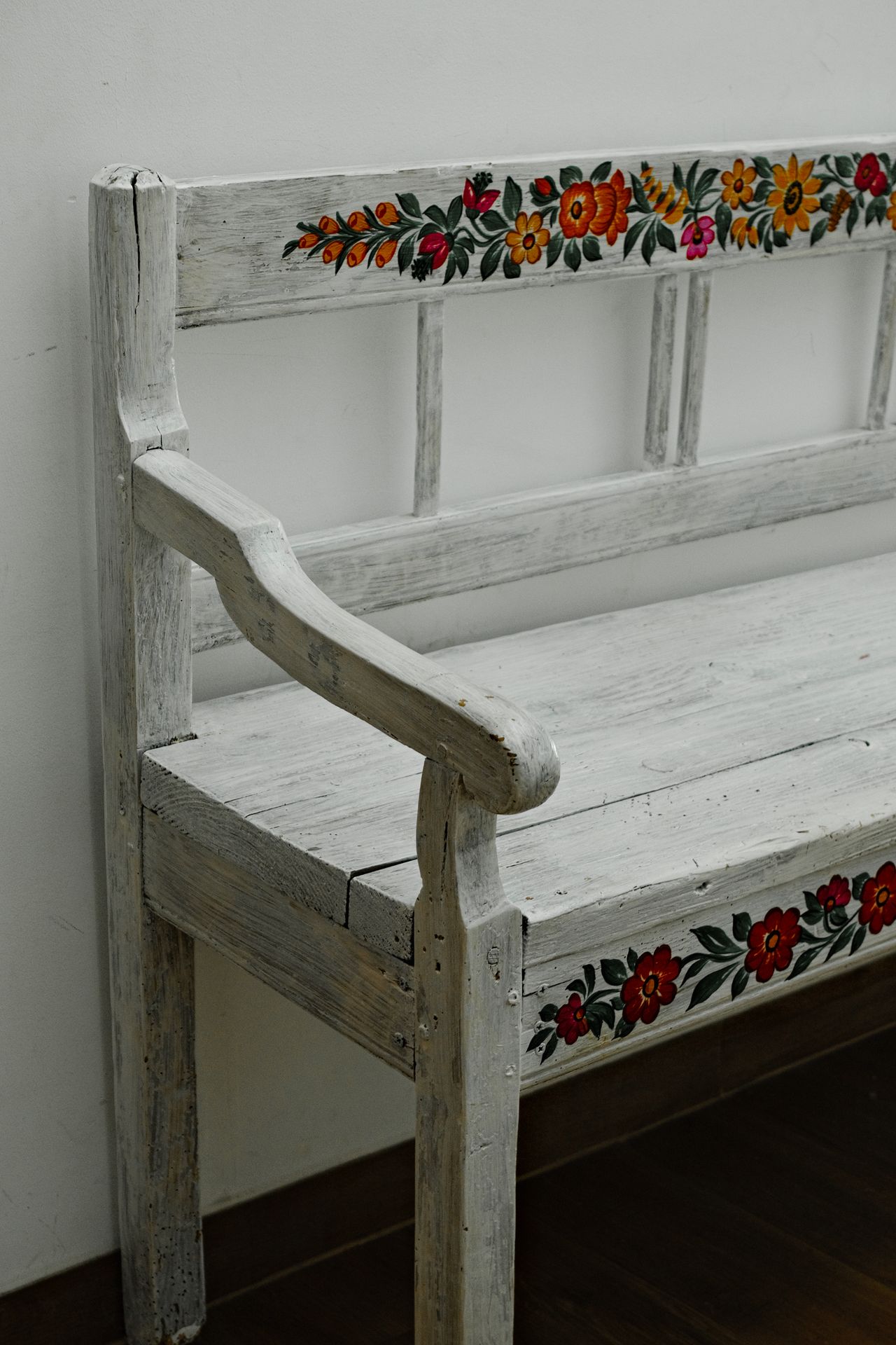 White wooden bench with hand-painted colourful floral designs