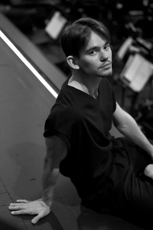 Free Stylish black and white portrait of a thoughtful man sitting on stage. Stock Photo