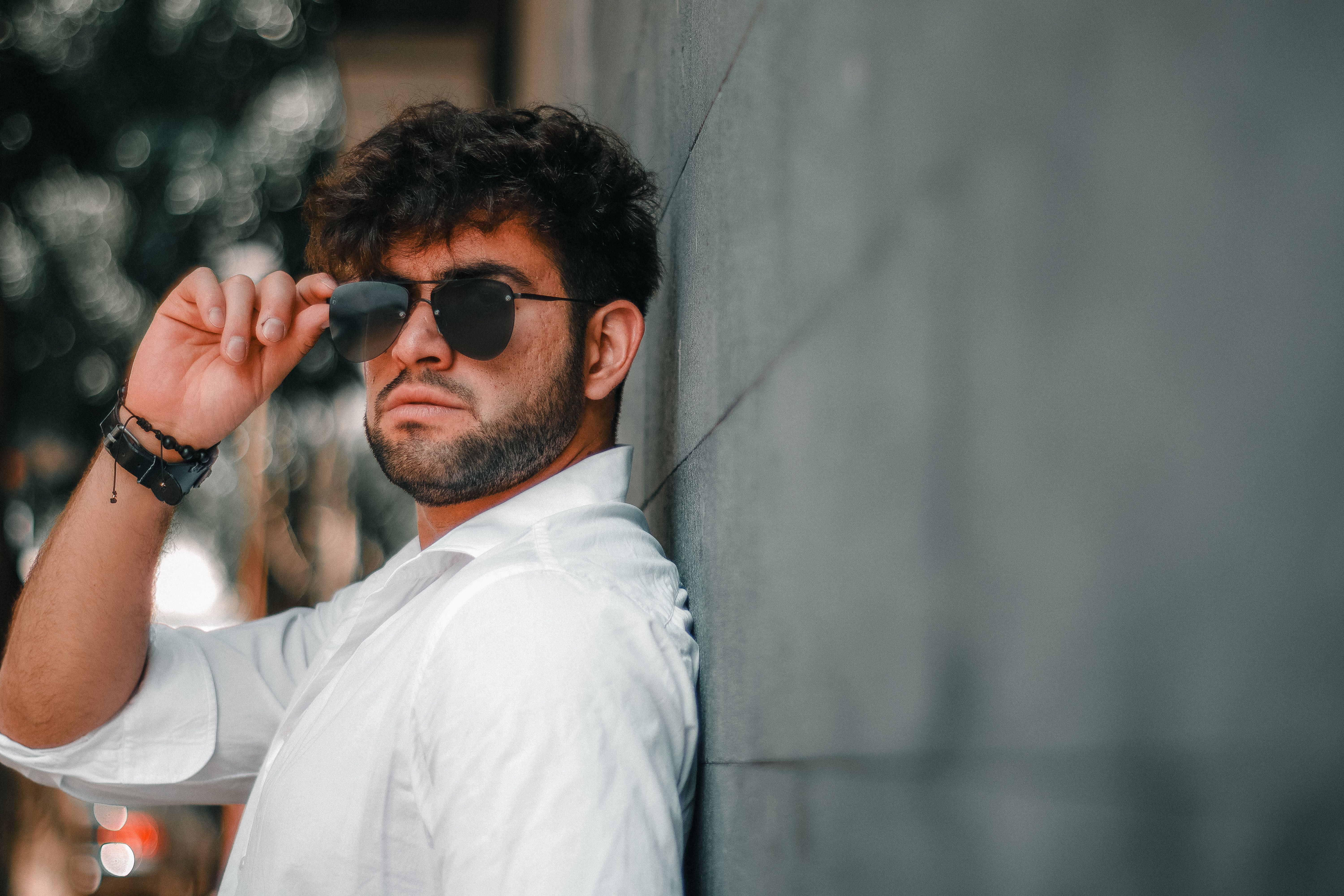 Stylish Man in Sunglasses Leaning Against Wall · Free Stock Photo