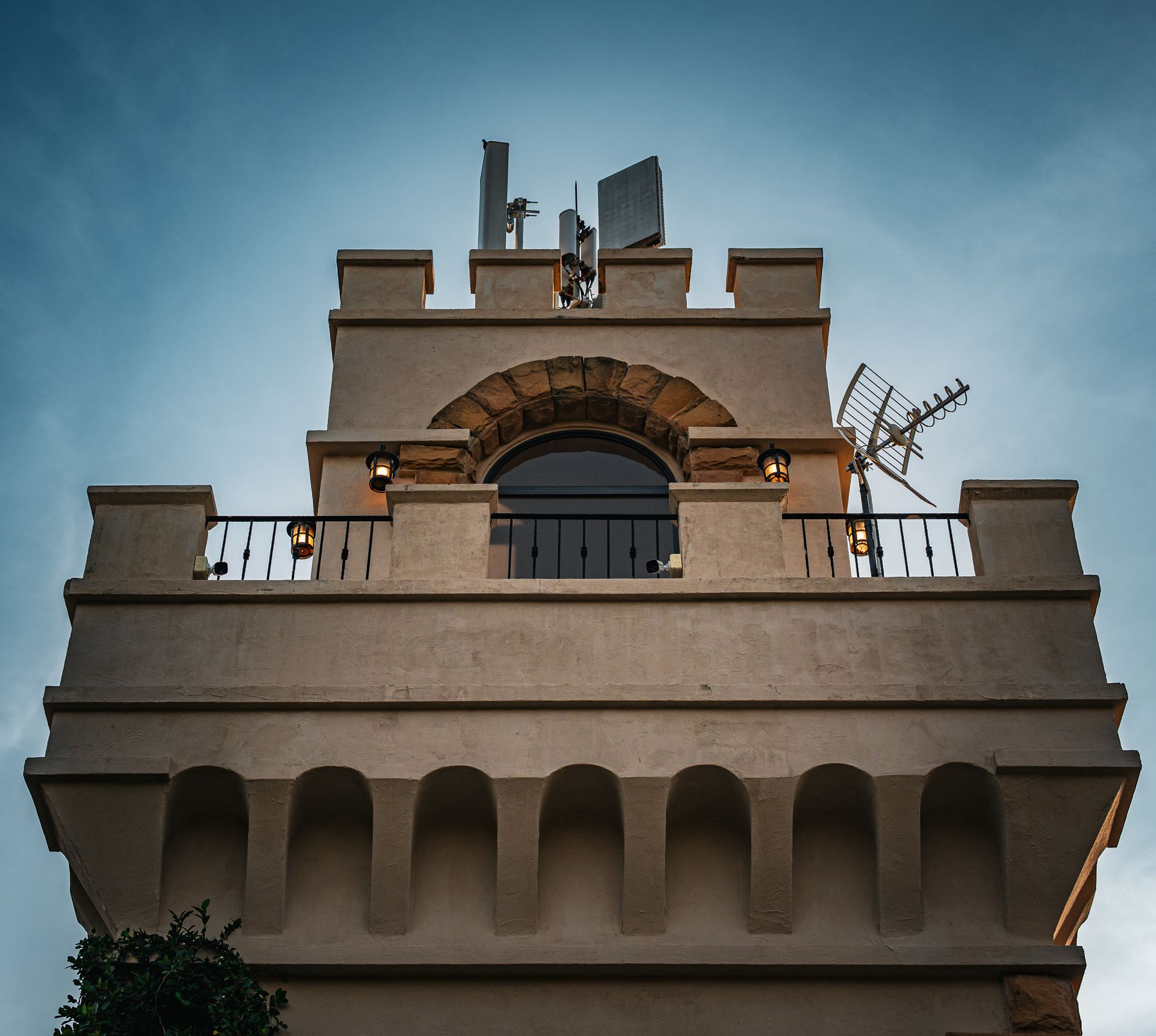 Low angle view of a tower with antennas set against a clear blue sky.