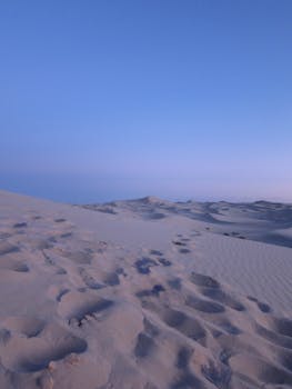Peaceful sand dunes under a pastel sky at twilight in El Paso, Mexico.